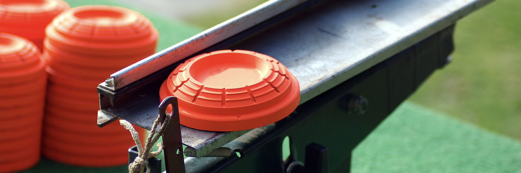 Orange clay targets are stacked on a launcher at a shooting range, ready for use by Bethany Lutheran College students participating in shooting sports or recreational activities.