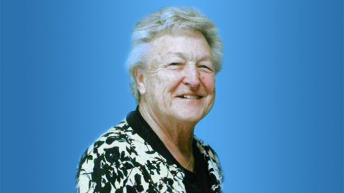 An older person with short gray hair, wearing a patterned black and white top, smiles against a blue background. If this is a Bethany Lutheran College faculty or staff profile photo, please provide the name and title for proper identification.