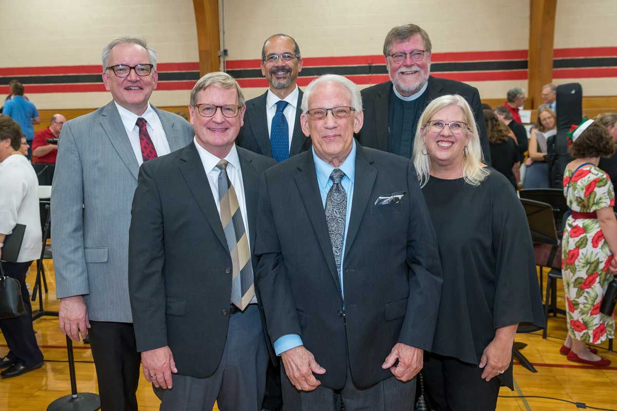 A group of seven people posing indoors in formal attire. These are the directors for the All-Bethany Choir Reunion Concert.