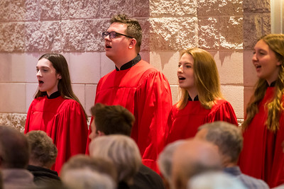 Four choir members wearing red robes sing together for the campus community at Bethany Lutheran College in Minnesota.