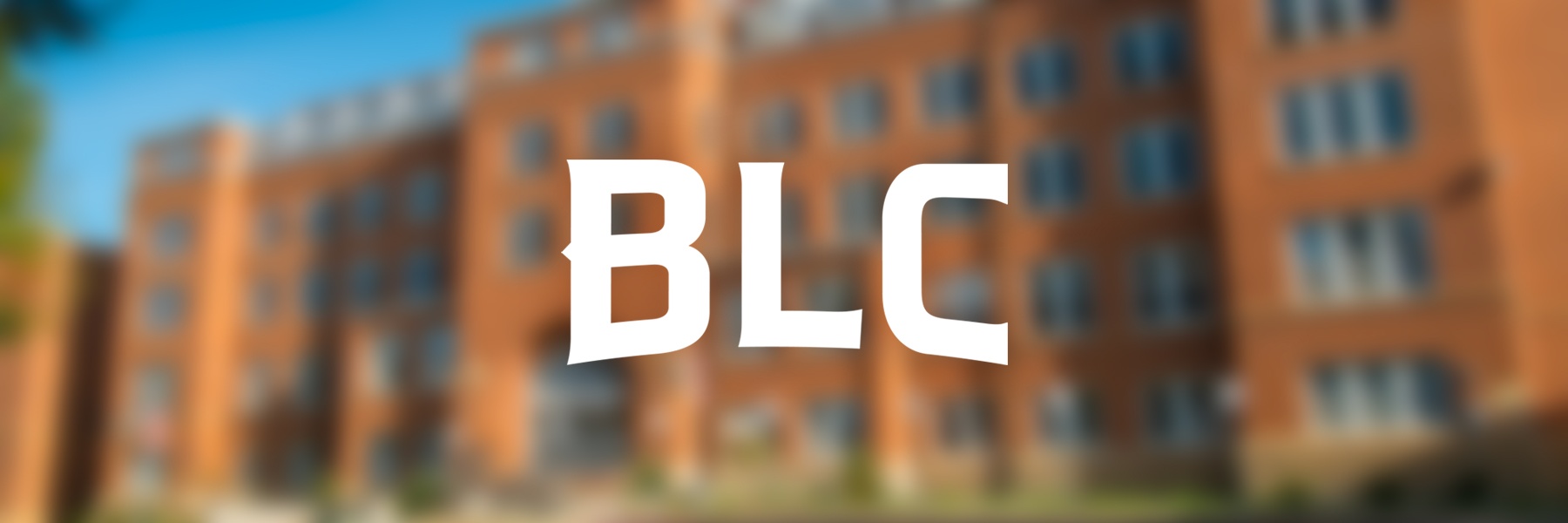 White BLC text over a blurred image of a large brick building with many windows in Mankato, Minnesota.