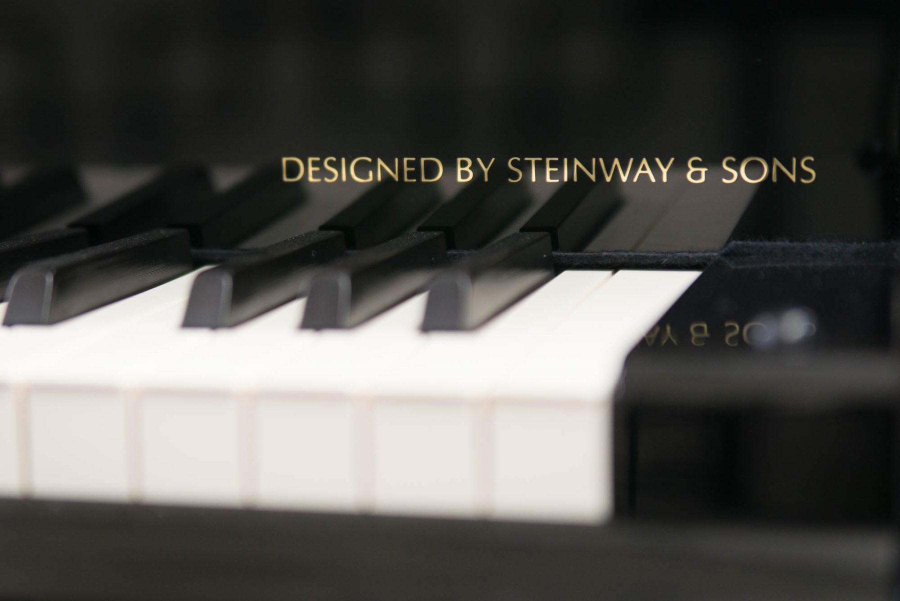 Close-up of piano keys with the inscription DESIGNED BY STEINWAY & SONS in gold, located on the Bethany Lutheran College campus.