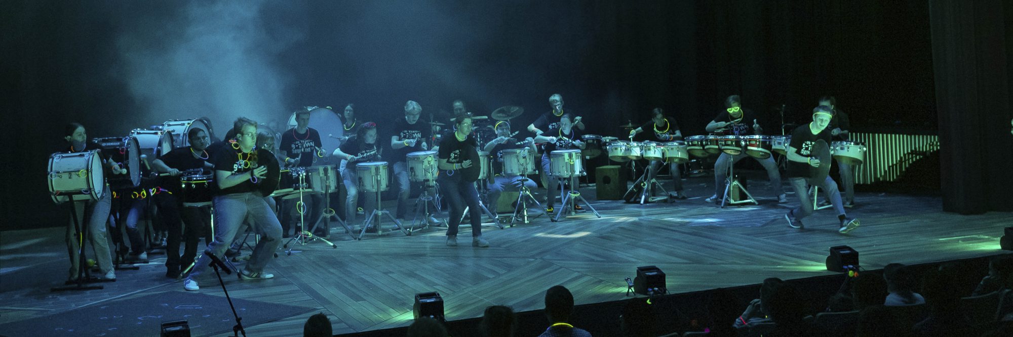 Musicians perform on stage under blue and green lighting at Bethany Lutheran College for the campus community.