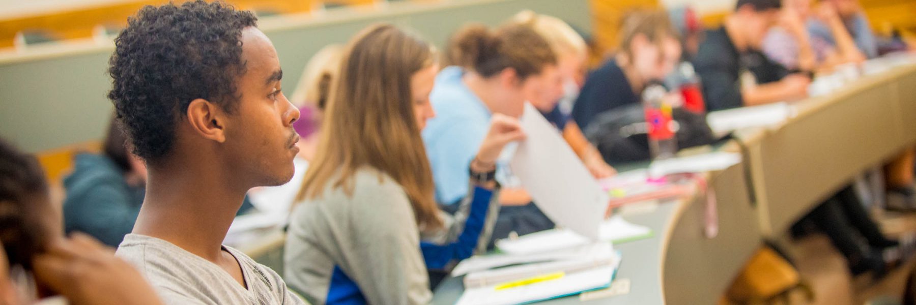 Students at Bethany Lutheran College in Mankato sit in a classroom, displaying strong engagement during a lecture.