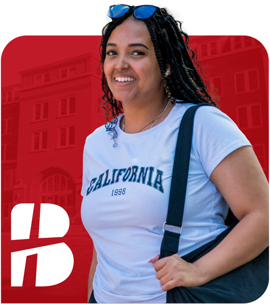 A smiling Bethany Lutheran College student with braided hair, wearing a college shirt and carrying a bag, stands against a red background.