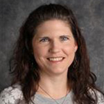 Amanda Stahl, Event Coordinator for the Advancement Department, against a gray backdrop.