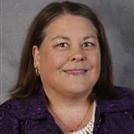 Anita Smith, Adjunct Faculty for the Clinical Mental Health Counseling – Graduate Programs Department, smiles against a gray background.