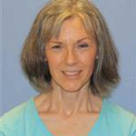 Barb Becker, Lessons Instructor for the Music Department, stands in front of a plain blue background.