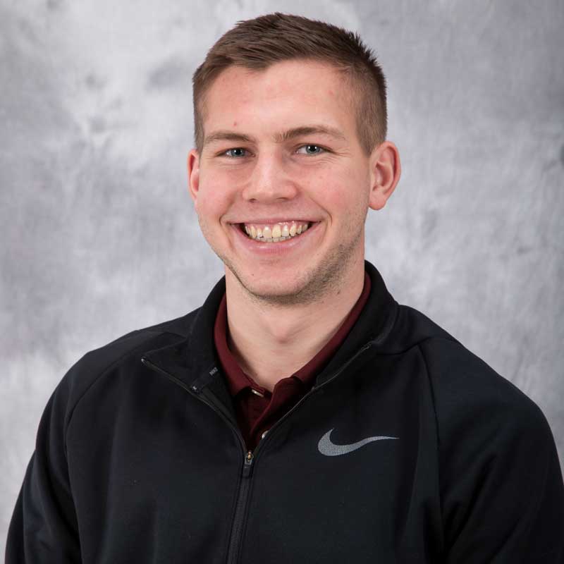 A young man with short hair smiles while wearing a black Nike jacket, representing student engagement in Mankato, Minnesota.