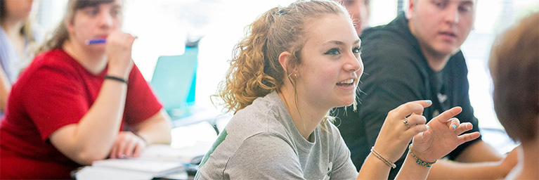 A student at Bethany Lutheran College leads a discussion with her classmates in a Mankato classroom while others listen and take notes.