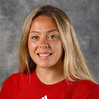 A smiling young woman with long blonde hair, wearing a red shirt, representing student engagement at Bethany Lutheran College.