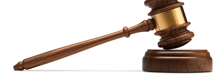 A judge’s gavel rests on a sound block, representing justice within the Bethany Lutheran College campus community.