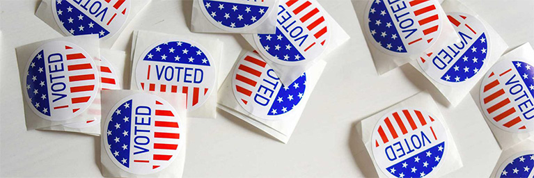 Several “I Voted” stickers featuring red, white, and blue stars are arranged together, representing student engagement on a Minnesota campus.