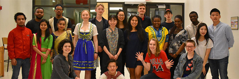 A diverse group of young adults from the campus community in Mankato, Minnesota, pose together and smile indoors.