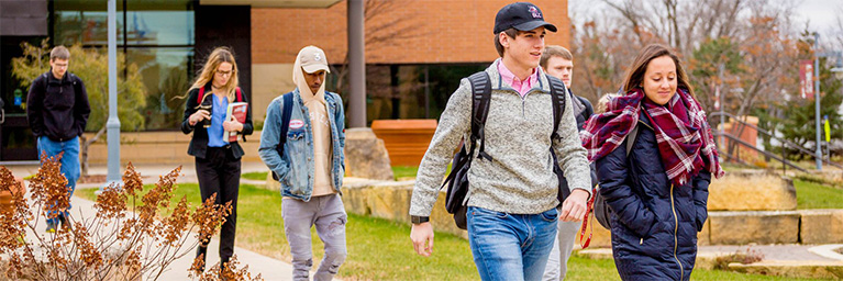 A group of college students walk together on the Mankato campus, representing the Minnesota campus community.