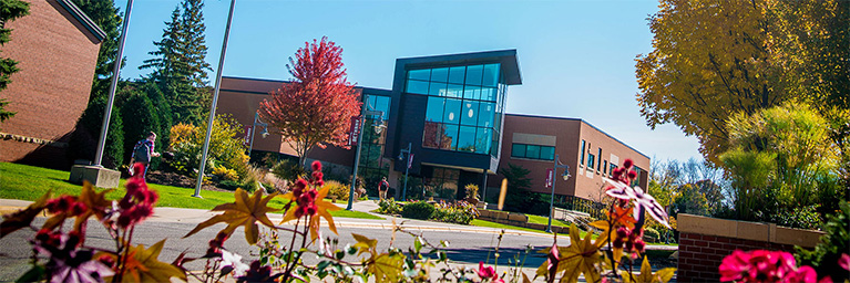 Modern brick building with large glass windows, surrounded by autumn trees on the Mankato campus, designed to foster student engagement.