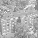 Aerial view of Bethany Lutheran College in Minnesota featuring a large brick academic building surrounded by trees and roads.