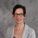 Bethel Balge, Lessons Instructor for the Music Department, poses atop a gray backdrop.