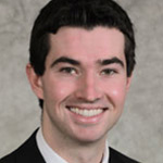 Brandon Polesky, Assistant Men's Basketball Coach and Academic Support for the Athletics Department, atop a tan background.