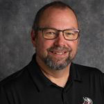 Brian Strom, Head Housekeeper for the Housekeeping Department, against a gray backdrop.