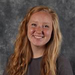 Bridget Lewison, Resident Hall Coordinator for the Residential Life Department, posing in front of a mottled gray background.