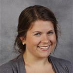 Connie Langhorst, Adjunct Faculty for the Music Department, smiles against a gray background.