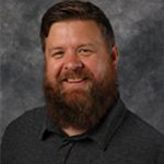 Dan Gerdts, Manager of the Spirit Store Department, against gray backdrop.