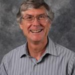 Doyle Holbird, Professor for the Biology Department, posed in front of a mottled gray background at Bethany Lutheran College.
