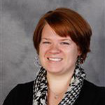 Emily Kimball, Assistant Professor for the Theatre Department, against a gray background.