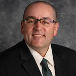 Jason Lowry, Vice President and Adjunct Faculty for the Academic Affairs Department, against a grey background.