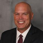 Jeff Younge, Director of the Financial Aid Department, set on a gray backdrop.