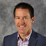 Jeffrey Lemke, Vice President of Admissions and Marketing of the Admissions Department, posing in front of a gray backdrop.