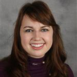 Jenna Londgren, Adjunct Faculty for the Clinical Mental Health Counseling – Graduate Programs Department, smiles while standing against a gray background.