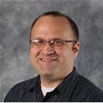 Jon Kovaciny, Web Development Specialist for the Institutional Communication Department, posed in front of a gray background.