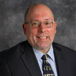 Jonathan Stadler, Professor for the Psychology Department, against a gray background.