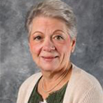 Joni Bode, Data Specialist for the Advancement Department, set against a gray backdrop.