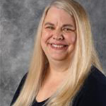 Julie Kjeer, Dean of Faculty for the Academic Affairs Department, in front of a gray mottled background.