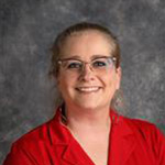 Laura Murray, Assistant to the Registrar in the Registrar's Office Department, against gray backdrop.