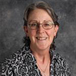 Leanne Stob, Assistant Professor for the Physics and STEM Department, against grey backdrop.
