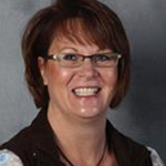 Lisa Shubert, Manager of Administrative Computing and Institutional Reporting in the Information Technology Services Department, against grey background.