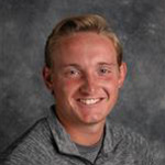 Michael Janes, Head Coach Tennis for the Athletics Department, against grey background.