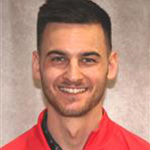 Mitchell DeKruif, Head Golf Coach of the Athletics Department, against a tan background.