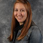 Renee Tatge, Registrar of the Registrar's Office Department, standing against gray background.