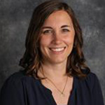 Stephanie Heidorn, Assistant Professor for the Media Arts Department, against gray backdrop.