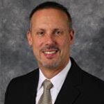 Ted Manthe, Vice President of the Student Affairs Department, Title IX Coordinator for the President's Office Department, and Instructor for Teaching Christian Faith for the Education Department, against a gray backdrop.