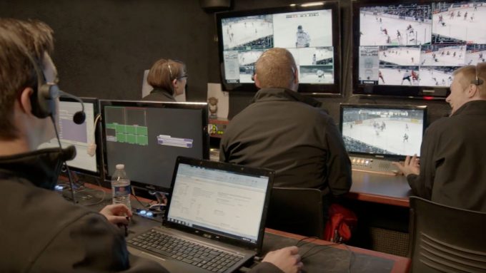 Four people in a control room at Bethany Lutheran College monitor hockey games, illustrating student activities and campus life.