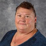 Wanda Hull, Housekeeping Technician for the Housekeeping Department, amongst gray backdrop.
