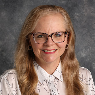Sara Edwards, Associate Professor for the Legal Studies Department, posed in front of a gray mottled background.