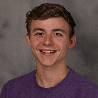 Noah Gernander, Adjunct Faculty for the Chemistry Department, is posed in front of a gray studio background.