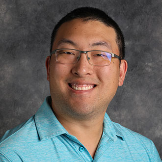 Michael Harting, Information Technology Specialist/Help Desk Support for the Information Technology Services Department, is posed against a gray textured background.